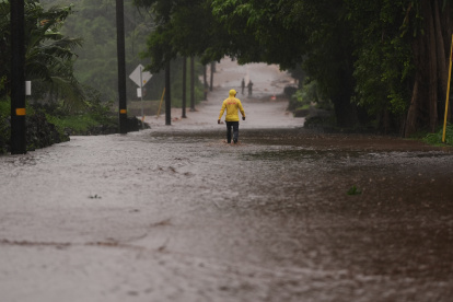 El capitán Lui Sales, del Departamento de Bomberos de Hawai, busca gente para ayudar mientras el agua de lluvia causada por el huracán Nolo inunda un tramo de la autopista Mamalahoa, Hawai, el sábado 26 de septiembre de 2026. (Foto AP/Gregory Bull)